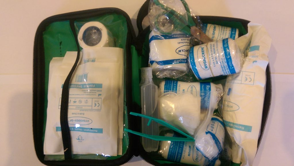 An unzipped, fully stocked green first aid bag 